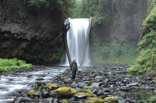 Image of person in front of waterfall. [Photo credit: Alan Dyck, USFS]