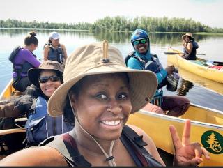 People of ethnic diversity preparing for a canoe trip in the wilderness.