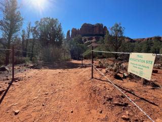 Image of a trail lined with fencing.
