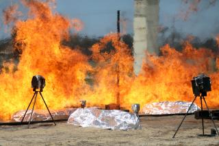 Two protected cameras record wildland firefighter emergency shelters surrounded and inside a test fire.