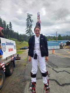 Young woman standing on stilts, smiling for the camera.