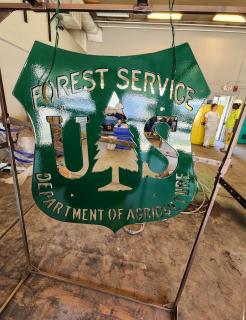 A Fosrest Service insignia made out of metal and painted in black (oversized)