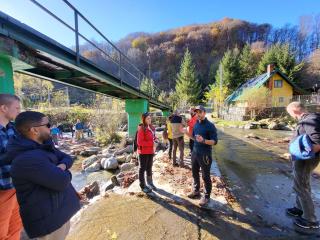 Workshop participants gather near a barrier to a river in Romania.