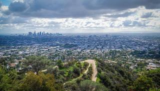 Aerial view showing the sprawling city of Los Angeles, with the city skyline in the distance.