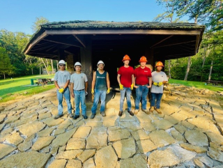 Group photo in front of stone shelter