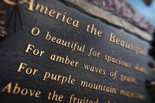 Closeup view of a bronze plaque with the words from the song America the Beautiful.