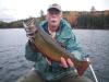 Man holding a brook trout in the middle of a lake