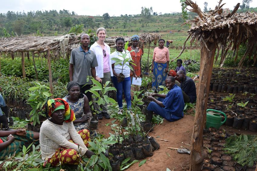 A group of people stand in a small farm.