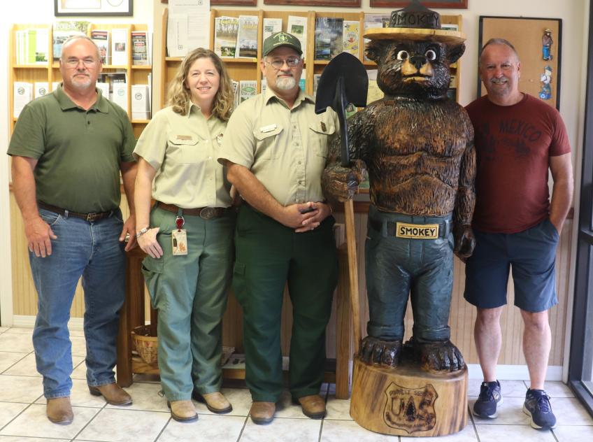 Group photo with carved Smokey Bear statue.