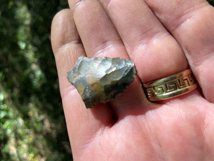 Closeup of a hand holding a piece of an arrowhead