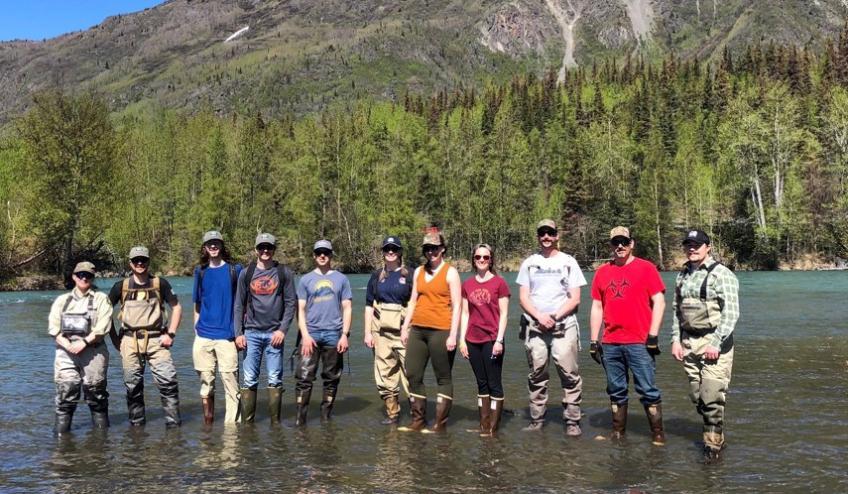 Group photo: Volunteers standing ankle deep in water.