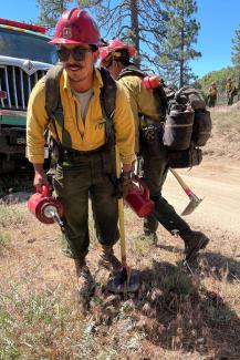 Wildland Firefighter Geoffrey Sobarzo carries drip torches at Thomas Mountain