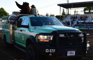 Green Truck with a man and a Man in a Bear Suit