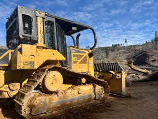 a dozer moves down a forest service road