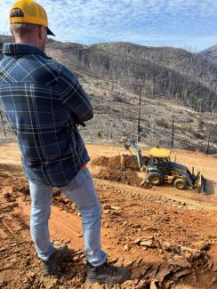 a man views road construction from a hill