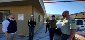 Several people gathered and talking outside of a building