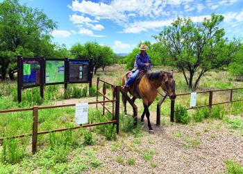A trail rider goes through the gate at the Casa Blanca Trailhead.