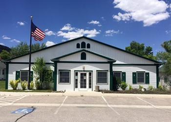 Front of the Ely Ranger District office that is white with dark green trim.