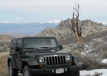 off-highway car on dirt road, mountains, rocks