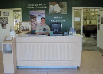 An employee behind the front desk of the Hudson-Meng Visitor Center.