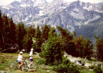 people mountain biking below a fabulous mountain range