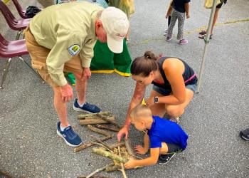 Smokey Bear helps child collect firewood