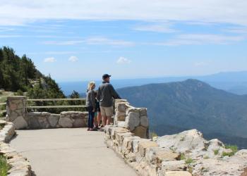 Two visitors take in the mountain views from the top of Sandia Crest