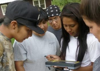 A group of volunteers gather around a device used to collect data