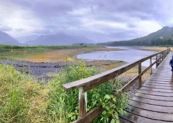 A person walks on a dock towards a waterway.