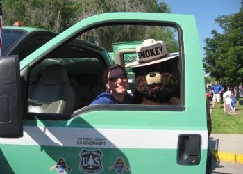 Smokey Bear smiles with an employee
