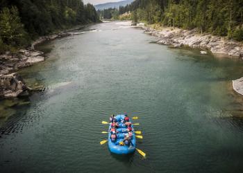 Rafters in a large raft float down a river