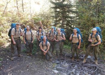 a group of young people in hard hats in a forest