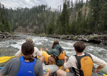 young people in life jackets rafting on a river