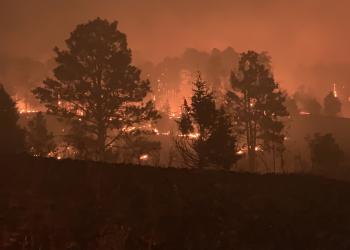 The 2023 Natick Fire glows orange at night with flames in the forest.