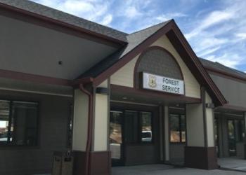 Forest Service sign over an entry in an office plaza setting.