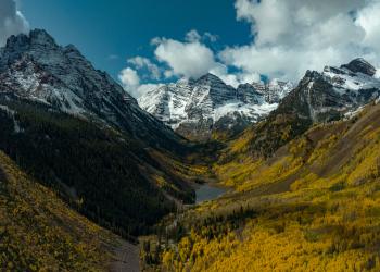Fall snowy Maroon Bells from a distance with lake
