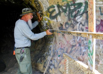 Pre-restoration photo of Sandia Cave graffiti 2015