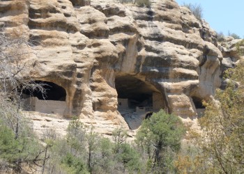 View of a cliff face and caves with prehistoric rock walls built in them