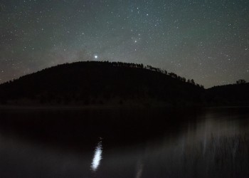 The Milky Way glows over the ridge as Jupiter reflects brightly on Snow Lake