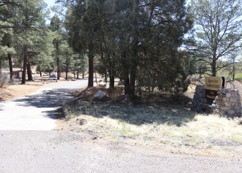 Photo of a site identification sign for Upper End Campground and the campground entrance road
