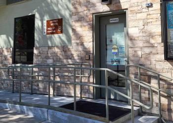 Building with forest Offices sign with an accessible ramp leading to the door.