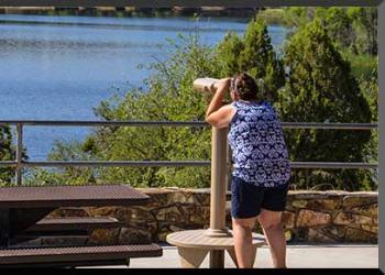 Person looking through telescope at Lynx Lake.