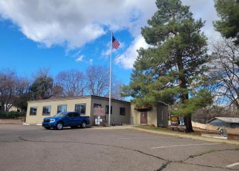 Front view of the Globe Ranger Station building with a cloudy sky in the background. 