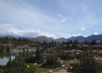Glacial lake basin with distance mountain peaks