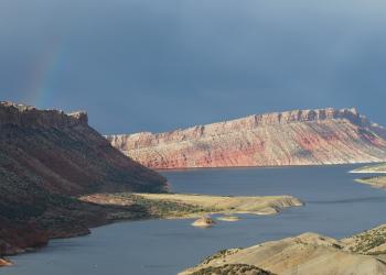 Picture of Flaming Gorge Reservoir with water and red bluffs and rainbow