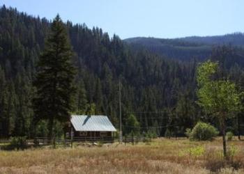 log cabin sits in field 