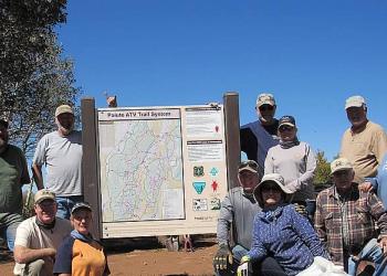 Volunteers members from the Sand Rock Ridge Riders pose next to the new White Pine kiosk they helped install