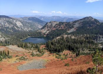 An alpine lake surrounded by mountains with fall colors.