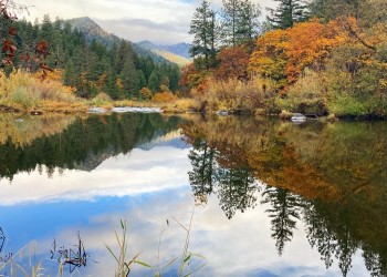 A calm river with the sky reflected in it. 