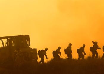 Bulldozer and Hotshot Crew with orange-cast background.